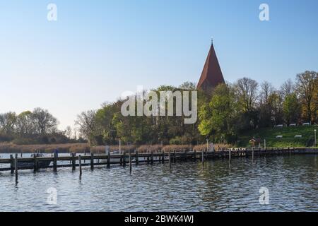 Holzsteg im Yachthafen an der Kirche in einer Bucht auf der Insel Poel bei Wismar in der Ostsee, blauer Himmel mit Kopierplatz Stockfoto