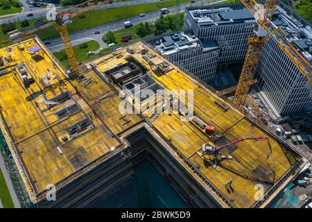 Baustelle von oben. Luftaufnahme der neuen Wohnung im Bau. Mitarbeiter arbeiten. Top-Ansicht Industriegebiet. Stockfoto
