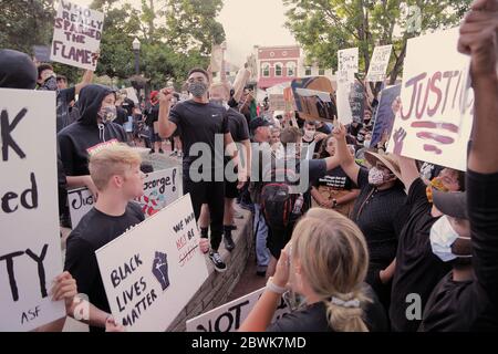 Bentonville, Arkansas, USA. Juni 2020. Protestler winkt Zeichen und chanten während einer meist friedlichen Demonstration über den Tod von George Gloyd auf dem Stadtplatz vor dem historischen Benton County Gerichtsgebäude. Als der Protest zu beenden schien, brach ein Konflikt mit Strafverfolgungsbehörden aus, die zwei Polizeifahrzeuge der Stadt und eine zweistündige Standzeit verursachten, bevor sie mit Tränengas zerstreut wurden. Quelle: Brent Soule/ZUMA Wire/Alamy Live News Stockfoto