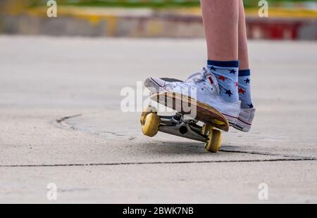 Nahaufnahme mit den Füßen eines jungen Mannes auf einem Skateboard. Stockfoto