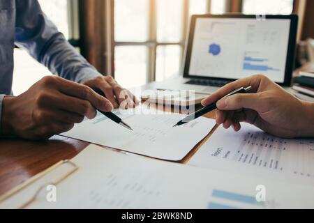 Die Kollegen betonen, dass sie über den Bericht über die Finanzergebnisse sprechen und mit den Finanzinformationen über die Papierkram mit einer Analyse über planni verglichen werden Stockfoto