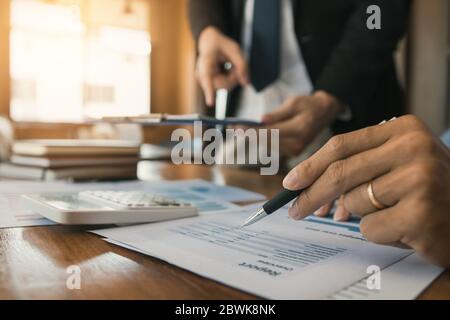 Die Kollegen betonen, dass sie über den Bericht über die Finanzergebnisse sprechen und mit den Finanzinformationen über die Papierkram mit einer Analyse über planni verglichen werden Stockfoto