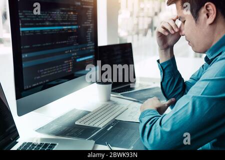 Softwareentwickler haben im Büro Kopfschmerzen bei der Codeanalyse. Stockfoto