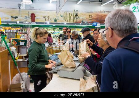 Weibliche Angestellte, die Obst und Gemüse in E Leclerc Supermarkt, St Malo, Bretagne, Frankreich wiegen Stockfoto