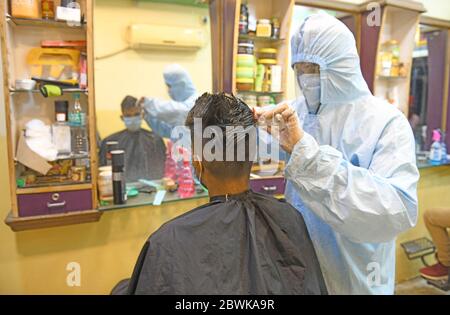 Beawar, Rajasthan, Indien - 1. Juni 2020: Ein Friseur mit persönlicher Schutzausrüstung (PSA) gibt einem Kunden in seinem Salon einen Haarschnitt, am ersten Tag der COVID-19 Sperre 5.0, in Beawar. Kredit: Sumit Saraswat/Alamy Live News Stockfoto