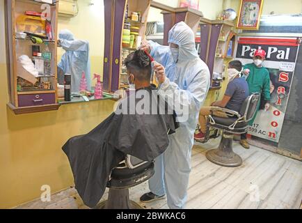 Beawar, Rajasthan, Indien - 1. Juni 2020: Barbier mit persönlicher Schutzausrüstung (PSA) besucht einen Kunden in seinem Salon, am ersten Tag der COVID-19 Sperre 5.0, in Beawar. Kredit: Sumit Saraswat/Alamy Live News Stockfoto