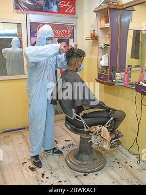 Beawar, Rajasthan, Indien - 1. Juni 2020: Ein Friseur mit persönlicher Schutzausrüstung (PSA) gibt einem Kunden in seinem Salon einen Haarschnitt, am ersten Tag der COVID-19 Sperre 5.0, in Beawar. Kredit: Sumit Saraswat/Alamy Live News Stockfoto