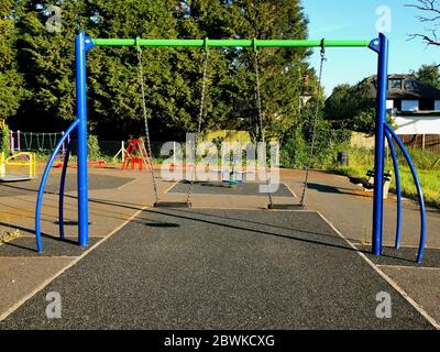 Bunte Schaukeln für Kinder und Spielgeräte im örtlichen Stadtpark Stockfoto