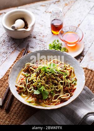 Traditionelles Sichuan (Szechuan) Chinesische Dan Dan Noodles mit gehacktem Schweinefleisch auf traditioneller Kulisse Stockfoto