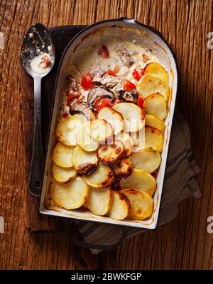 Traditioneller britischer Mackerel und geräucherter Bacon Hot Pot mit Kartoffeln, Pilzen und Tomaten in einer cremigen Sauce Stockfoto