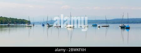 Panorama mit ankenden Segelbooten und kleinen Yachten am Ammersee. Der Ammersee ist Teil des sogenannten Fünfseenlandes. Stockfoto