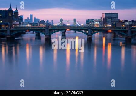 Allgemeine Ansicht der Themse im Zentrum Londons bei Sonnenaufgang, mit Southwark Bridge, Tower Bridge und Wolkenkratzern am Canary Wharf, nach der Einführung von Maßnahmen, um das Land aus der Blockierung zu bringen. Stockfoto