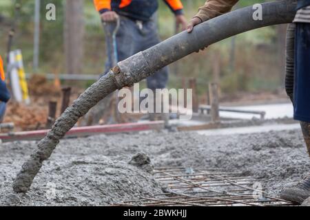 Gießen und Nivellieren einer neuen Betonplatte für ein im Bau befindlichen Wohnhaus in Melbourne Australien Stockfoto