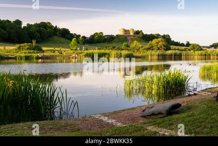 Bristol, England, UK - 27. Mai 2020: Die Leute sitzen in der Abendsonne und fischen im Herzogin Teich in Stoke Park, im Norden von Bristol, mit dem Dower House beh Stockfoto