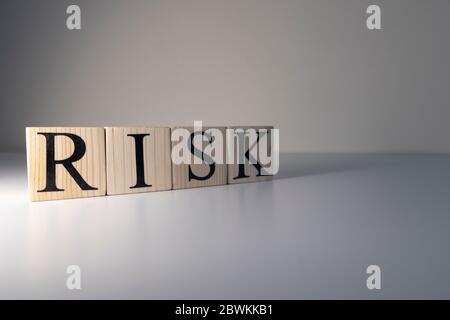 Das Wort Risiko wurde mit Holzwürfeln geschrieben. Stockfoto