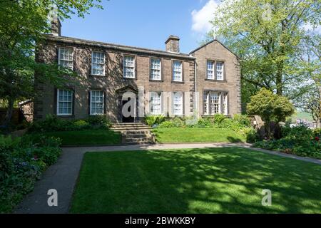 Blick auf das Bronte Parsonage Museum in Howarth, West Yorkshire vom Garten aus an einem sonnigen Sommernachmittag Stockfoto