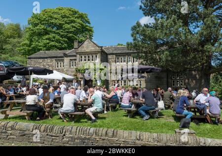 Kunden sitzen im belebten Biergarten von Howarth Old Hall, einem historischen Gasthaus im Yorkshire Dorf Howarth Stockfoto
