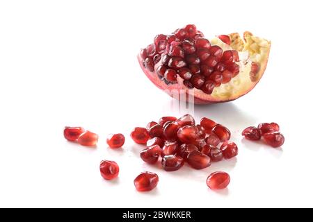 Stück Granatapfelfrucht mit roten saftigen Samen isoliert mit Schatten auf weißem Hintergrund, kopieren Raum Stockfoto