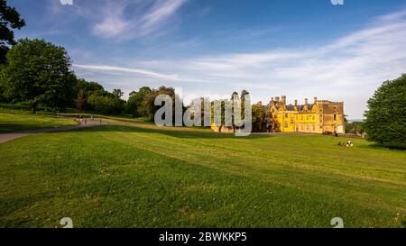 Bristol, England, Großbritannien - 9. Mai 2020: Menschen spazieren, radeln und picknicken in einer Parklandschaft neben dem Ashton Court Herrenhaus in Bristol. Stockfoto