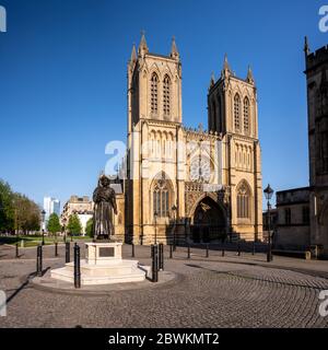 Bristol, England, UK - 19. April 2020: Abendsonne scheint auf der Westseite der Bristol Cathedral und der Statue von Raja RAM Mohan Roy in College Green, Stockfoto