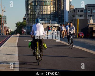 London, England, Großbritannien - 19. Juli 2016: Pendlerradler in Bürokleidung fahren auf dem neu eröffneten Cycle Superhighway 6 über die Blackfriars Bridge. Stockfoto