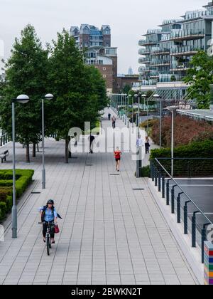 London, England, Großbritannien - 18. Juni 2013: Wanderer, Radfahrer und Jogger nutzen den Themse Path neben neu erbauten Wohnhäusern in Wandsworth. Stockfoto