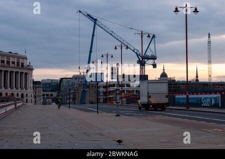 London, England, Großbritannien - 15. Juni 2011: Ein Mann radelt bei Sonnenaufgang über Londons Blackfriars Bridge Bürgersteig Stockfoto