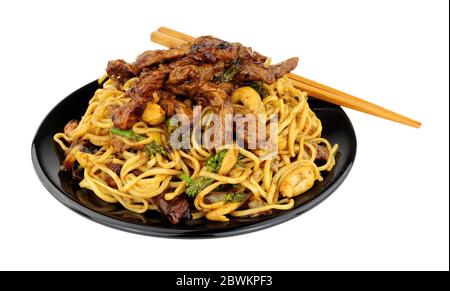 Rindfleisch in schwarzer Bohnensauce mit Eiernudeln und Cashewnüssen Mahlzeit auf weißem Hintergrund isoliert Stockfoto
