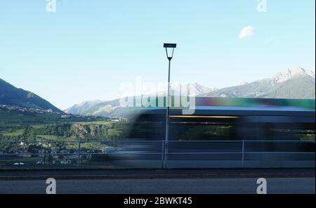 Bunte Regionalzug verschwommen in Bewegung, Meran, Südtirol, Italien. Stockfoto