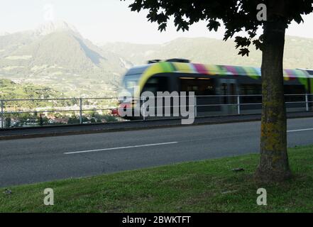 Bunte Regionalzug verschwommen in Bewegung, Meran, Südtirol, Italien. Stockfoto