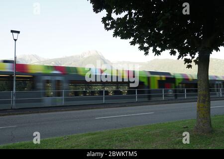 Bunte Regionalzug verschwommen in Bewegung, Meran, Südtirol, Italien. Stockfoto