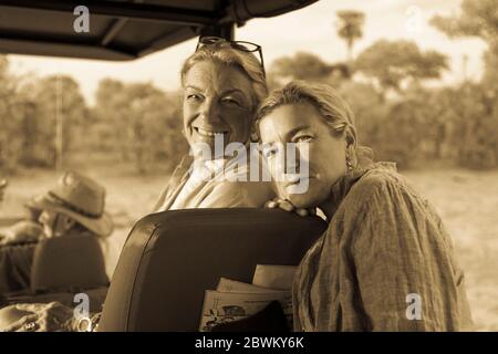 Ältere Frau und reife Tochter, zwei Generationen von Frauen in einem Safari-Jeep lachen. Stockfoto