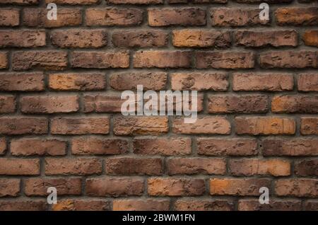 Dunkelrot und gelb Backstein Wand Hintergrund, Muster und Textur Stockfoto