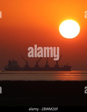 Der Sonnenuntergang auf einer Küste mit einem Schiff. Selektiver Fokus. Geringe Schärfentiefe. Hintergrundunschärfe. Stockfoto