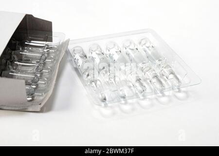 Medizinische Ampulle aus Glas mit Injektionslösung auf weißem Tisch. Stockfoto