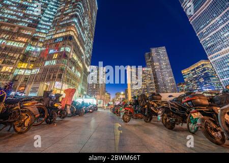 PEKING, CHINA - NOVEMBER 27: Nachtansicht einer Finanzdistrikt Straße mit Motorrädern und Motorroller am 27. November 2019 in Peking geparkt Stockfoto