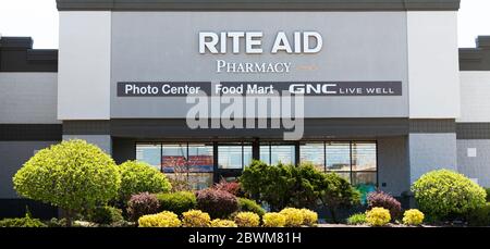 Bay Shore, New York, USA - 25. April 2020: Die Vorderseite einer Ritus Aid Apotheke mit Büschen, Sträuchern und Bäumen auf dem Parkplatz. Stockfoto