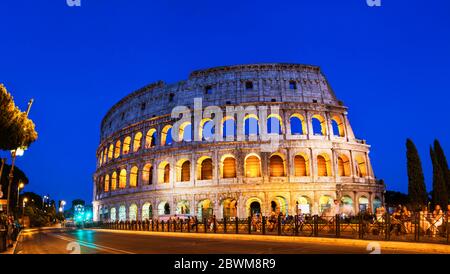 Rom, Italien. Menschen vor dem beleuchteten Kolosseum bei Nacht, Panoramablick auf berühmte Wahrzeichen der Stadt Rom, Italien Stockfoto