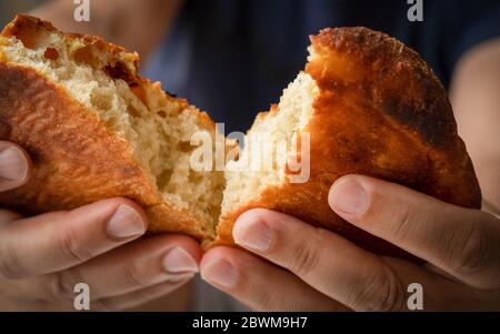 Frisch gebackenes Brot vom Bäcker. Bäcker hält frisches Brot in den Händen. Rustikaler Stil. Kurz bevor der hungrige Mensch Brot essen. Stockfoto