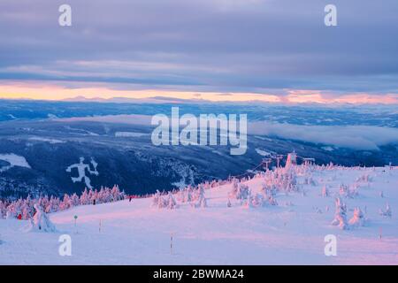 Hafjell, Norwegen. Luftaufnahme des Skigebiets Hafjell in Norwegen mit Skifahrern, die im Winter mit Bergen die verschneiten Pisten hinunterfahren Stockfoto