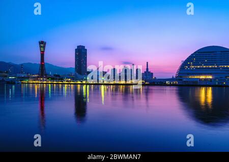 Kobe, Japan. Blick auf den frühen Sonnenaufgang in Kobe, Japan mit violettem und blauem Himmel. Wolkenloser Himmel mit Hafen und Silhouetten von zahlreichen Wolkenkratzern und Port To Stockfoto