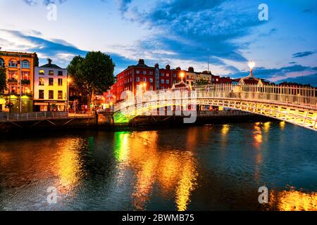 Dublin, Irland. Nacht Blick auf berühmte beleuchtet Ha Penny Bridge in Dublin, Irland bei Sonnenuntergang Stockfoto