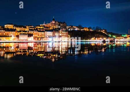 Stockholm, Schweden. Blick auf Sodermalm in Stockholm, Schweden mit beleuchteten historischen Gebäuden in der Nacht. Spiegelung im Fluss Stockfoto