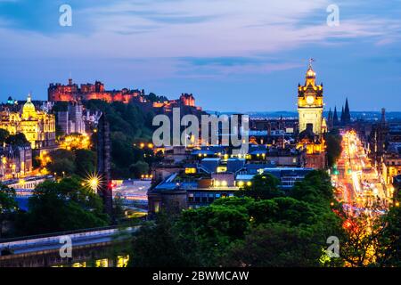 Edinburgh, Großbritannien. Luftaufnahme von Calton Hill in Edinburgh, Schottland. Die Stadt mit beleuchteten Schloss und Uhrturm in der Nacht. Wolkiger Himmel bei Sonnenuntergang Stockfoto