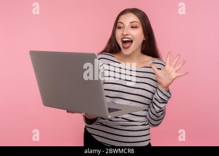 Hallo! Porträt der freundlichen Frau im gestreiften Sweatshirt winken Hand am Laptop-Bildschirm, sagen Hallo, Kommunikation per Videoanruf, Online-Konferenz. ich Stockfoto