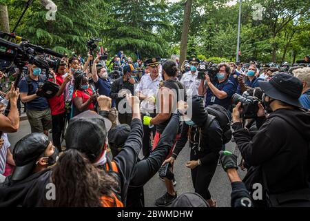 Demonstranten und Polizeibeamte schließen sich den Händen und beugen sich als Zeichen der Einheit in der Nähe des Washington Square Park, New York, NY am 1. Juni 2020. Proteste finden im ganzen Land nach dem Tod von George Floyd statt, während in Polizeigewahrsam in Minneapolis von einem Zuschauer gefilmt wurde. (Foto von Christopher Lazzaro/Alive Coverage/Sipa USA) Stockfoto