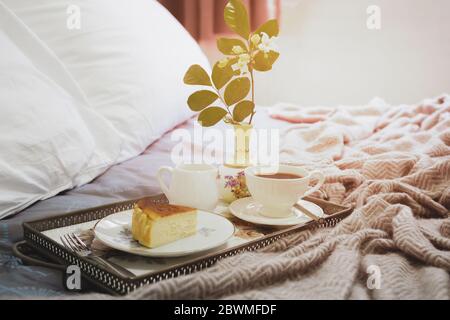Frühstück im Bett Scheibe Cheesesescake mit Kaffeetasse Blume in einem Tablett Stockfoto