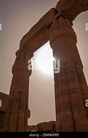 Säulen in der alten ägyptischen Hypotythythil Halle des Karnak-Tempels in Luxor mit Sonnenlicht durchplatzen Stockfoto