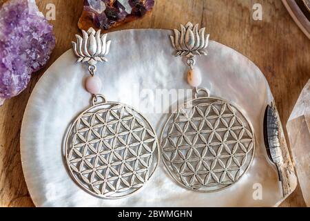 Schöne heilige Geometrie Metall Ohrringe auf Muschel Hintergrund Stockfoto