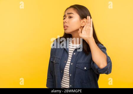 Ich kann nicht hören! Porträt von Mädchen in Denim-Hemd Hand in der Nähe des Ohres, aufmerksam zuhören mit Interesse private Unterhaltung, vertrauliche Gespräch. indo Stockfoto